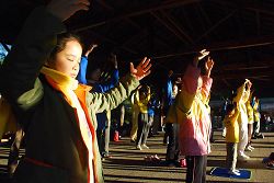 圖：法輪功學員和小弟子在日出的阿里山峰頂的祝山，迎著第一道晨曦煉功弘法。