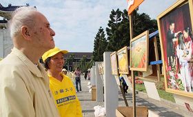 排字的四周同時展出「大法弟子證實法攝影作品展」，市民認真地觀看作品集，及聽取法輪功學員的解說