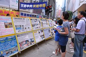 香港維多利亞公園附近的真相展板點，許多民眾駐足觀看法輪功真相