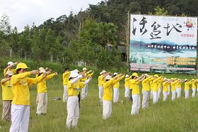 靠近日月潭入口的魚池鄉長紅茶休閒廣場旁，近百位法輪功學員演示功法。