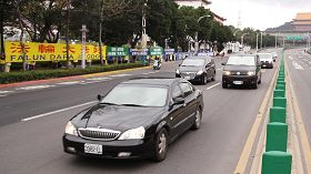 '北京市長郭金龍車隊（右），二月十九日早上行經台北市中山北路時，遇到法輪功學員拉橫幅抗議，立即加快車速倉皇而逃。'