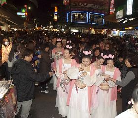 法輪功學員組成的仙女隊伍深受市民的喜歡，大家爭先恐後領取繫有小蓮花的「法輪大法好」書籤