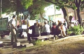 大陸遊客逛六合夜市，累了歇一會兒，剛好來看看展板、電視，了解法輪功真相。