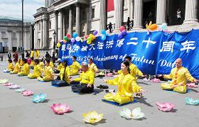 '來自英國各地的法輪功學員，歡聚倫敦市中心的「鴿子廣場」慶祝大法洪傳二十週年並祝賀師父生日。'