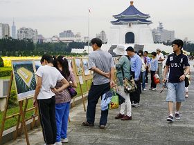 許多路過的遊客，圍觀在法輪功的真相圖片展前