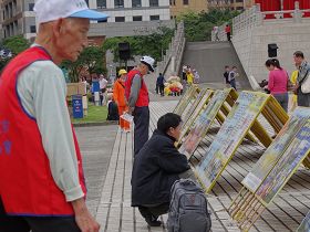 真相展板前一直有各地的遊客觀看