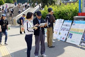 市民們通過真相圖片展板在了解法輪功真相