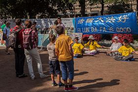 '赫爾辛基的海濱公園裏，大量遊客閱讀法輪功真相展板'