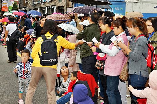 '沿途觀眾紛紛接受法輪功學員派發的真相傳單'