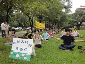 '星期日下午，青年學子在興大校園裏煉法輪功。一旁走道上學員正在為民眾做介紹。'