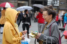 '風雨中人們駐足了解真相，簽名反迫害'