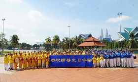 '活動結束前法輪功學員在蒂蒂旺莎湖濱公園廣場合影，恭祝師尊生日快樂。'