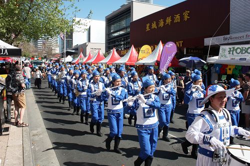 圖1-2：身著藍白色古裝，步伐矯健，精神抖擻，陣容整齊的法輪大法「天國樂團」。