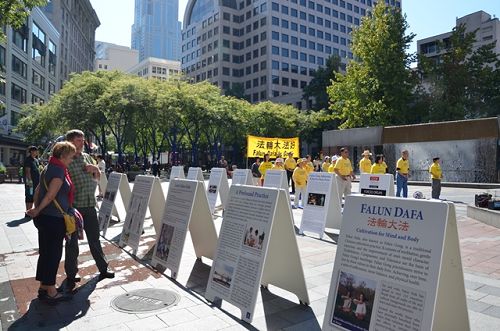 圖1：西雅圖法輪功學員在市中心擺放介紹法輪功的展板並演示法輪功功法