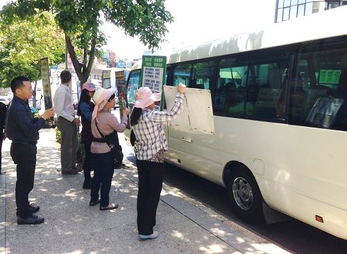 圖1：法輪功學員在澳洲布里斯本中國城遊客上下車的地方舉展板。