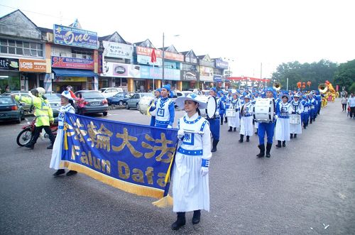 '法輪功遊行隊伍走在士古來大學城主要大街上，不但傳播著法輪功的真相，也給當地民眾帶來過年的喜慶。'