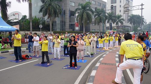 圖：雅加達法輪功學員在週日無車日集體煉功，吸引著人們的目光，並駐足了解法輪功。