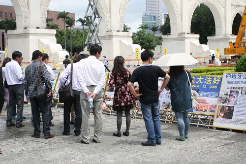 大陸、香港、馬來西亞、新加坡遊客，駐足在真相圖片前觀看