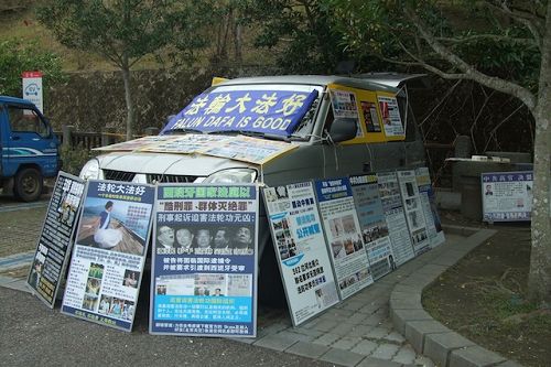 玄光寺停車場上擺滿真相展板的車子，後座還有一台電視不斷播放真相，常有遊客停下腳步仔細觀看。