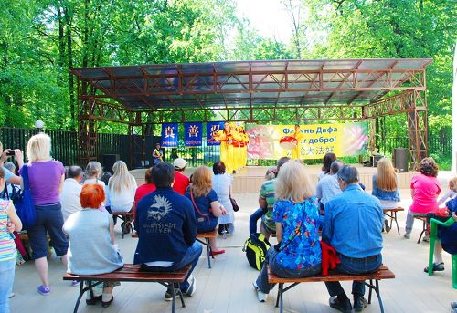 莫斯科「一隻螞蟻」公園裏，遊人興致勃勃地欣賞法輪功學員慶祝大法日的文藝表演