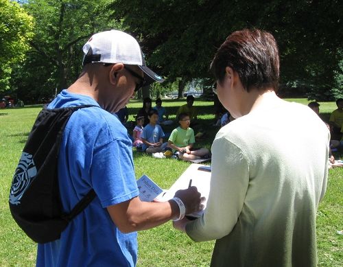 圖2，遊客在反活摘器官徵簽表上簽名