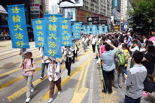 圖9-14：法輪功陣容龐大整齊的遊行隊伍吸引中西遊客及港民駐足觀看，紛紛舉起相機、手機拍照。