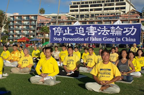 圖1-2：紀念和平反迫害十五週年，聖地亞哥法輪功學員在當地著名的拉荷亞海灣風景點集體煉功，傳播真相。許多遊人駐足了解真相。