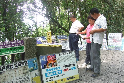 圖1：玉尾（中）在玄光寺青龍步道上給大陸遊客講述法輪功無辜遭受中共迫害的真相。