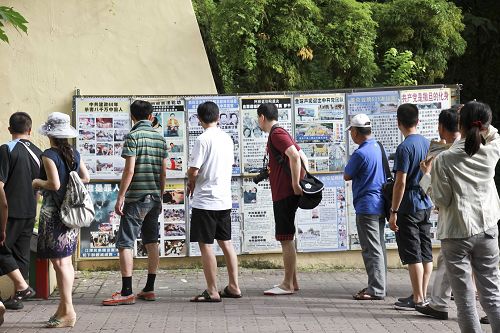 在很多大陸遊客登階梯到英國領事館參觀前也有一排法輪功真相展板，很吸引路過遊客觀看了解真相。