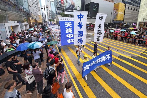 法輪功學員在集會結束後，緊接著進行「法辦元凶、停止迫害」的遊行活動。