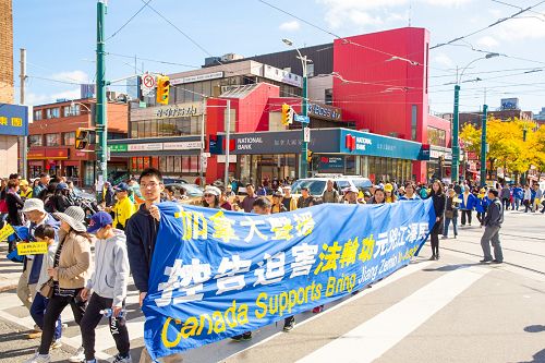 圖1-9:二零一五年十月十日中午，多倫多法輪功學員在市中心舉行今年訴江以來的第二次訴江大遊行，所到之處引起民眾的關注，很多民眾表示支持並在制止活摘的請願信上簽名。