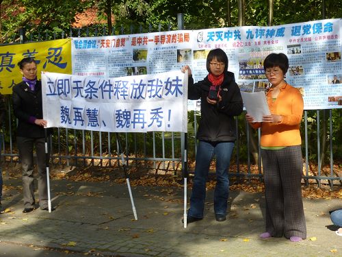 魏再群女士在中共駐丹麥使館門前，宣讀她給四川成都華陽鎮公檢法部門工作人員的公開信。奉勸他們不要再跟隨江澤民犯罪集團，犯下迫害法輪功修煉人的罪行，使自己走上一條絕路。