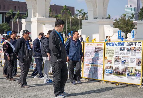 仔細觀看真相展版的大陸遊客。