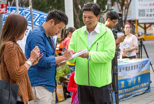 圖1：十二月六日，國際人權日前夕法輪功學員於高雄市博愛路、裕誠路口舉辦舉報聯署活動，聲援中國民眾控告江澤民活動」。