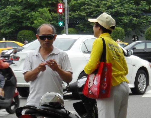 圖5：法輪功學員為專程停車了解活動的民眾講述真相。