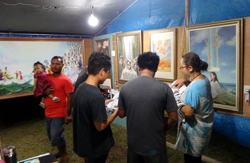 圖1-6：「真善忍國際美展」來到塞班島火樹節，每天都有大批的民眾駐足聆聽法輪功學員的講解