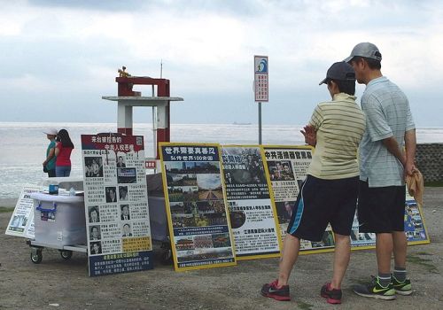 圖4：花蓮七星潭海邊，遊客觀看法輪功真相展板