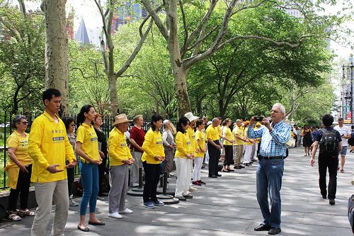 路人被法輪功學員的功法演示所吸引，紛紛拍照