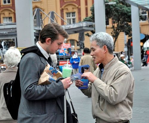 法輪功學員向路人介紹功法