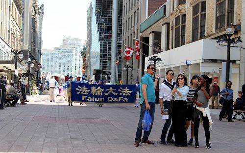 來自德國的Ceyda（中）和她的幾個朋友來到渥太華旅遊，正好遇到天國樂團遊行，他們就走在樂團的前面一直用手機自拍和天國樂團一起行進的情景