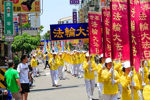 慶祝活動學員們精神抖擻舉著旗幟和橫幅，上面寫著：「慶祝世界法輪大法日」、「法輪大法好」、「真、善、忍」等與民眾分享修煉的喜悅。