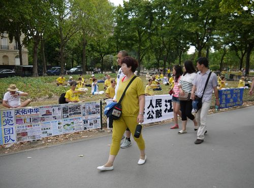 圖5-7：中國大陸遊客路經法輪功真相展板