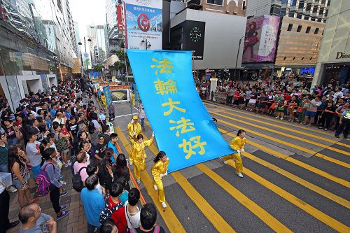 圖1-2：香港法輪功學員於二零一五年七月十八日，遊行從九龍區旺角、佐敦，再到尖沙咀廣東道，抵達終點天星碼頭。沿途吸引港民及中西旅客觀看。