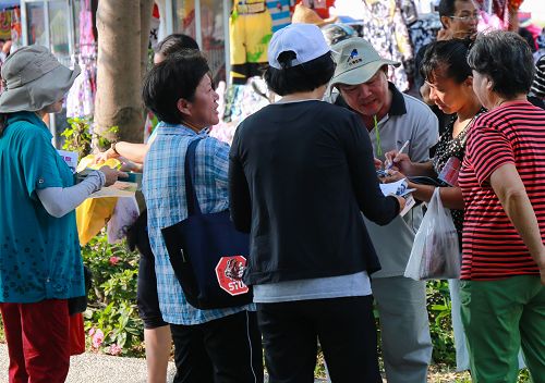 高雄市法輪功學員設展位向民眾徵簽，制止中共迫害法輪功，民眾響應熱烈。了解真相的人們紛紛簽名，期盼早日將惡人繩之以法。