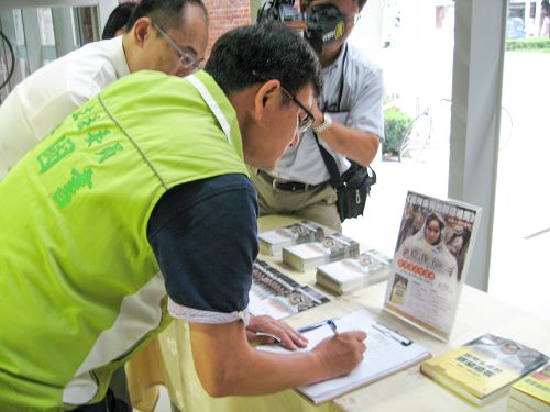 圖1：立委黃國書正在「刑事舉報江澤民」聯署書上簽名。