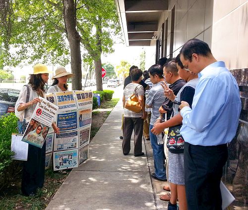 向休士頓中領館前等待簽證的人們展示法輪功真相圖片