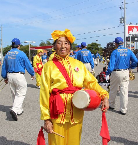 圖：八十二歲的法輪功學員果女士參加腰鼓隊，走完全程近兩小時的遊行。