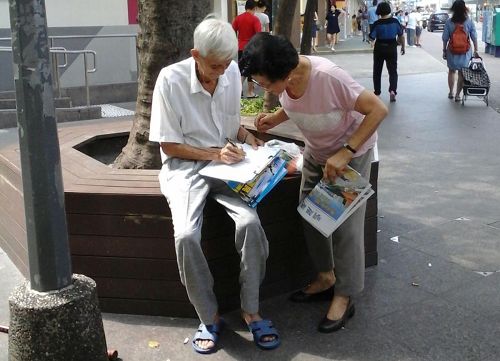 圖：老學員的徵簽舉報江澤民，得到頗多市民簽名。