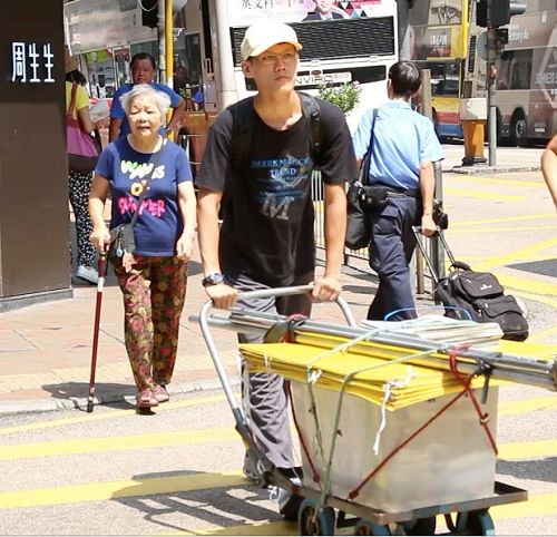 圖8. 虎科大研究生陳冠廷（推車者）靠打工收入，積蓄下來的錢做旅費，到香港講真相，看世人明白真相後的喜悅感到非常欣慰，覺得非常有意義。