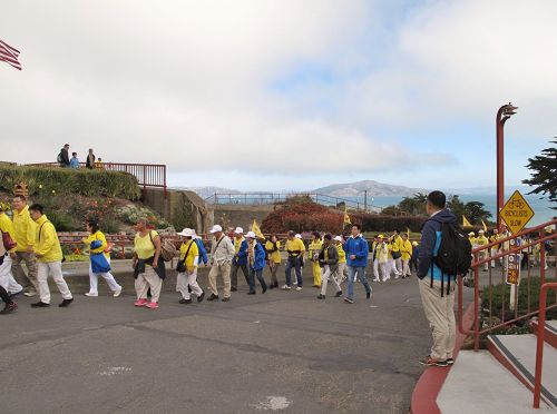 圖2： 二零一六年十月二十三日，一位大陸遊客在金門大橋默默注視著即將徒步出發的法輪功學員隊伍，並一直跟著學員徒步遊行